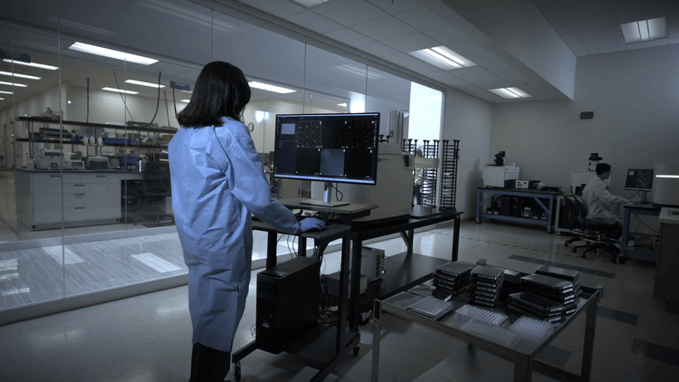 Scientist working on ImageXpress HCS.ai Advanced Duo High-Content Screening System