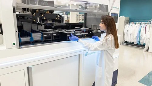 Female researcher using the CellXpress.ai Automated Cell Culture System in the lab